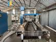 Automatic baling machine with shrink tunnel for bottles and jars in bales.