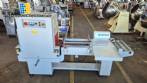L-shaped packaging sealer with semi-automatic shrink tunnel.