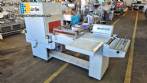 L-shaped packaging sealer with semi-automatic shrink tunnel.
