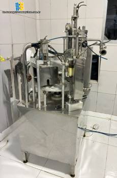 Mirainox rotary carousel filling and dosing machine with automatic sealer for liquids and semi-viscous products in cups.