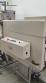 Label applicator machine with steam-operated shrink tunnel for sleeves.